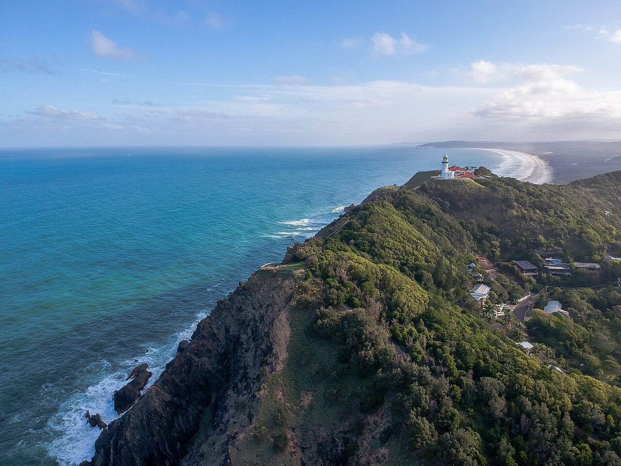Aerial view of Cape Byron headland and lighthouse above the ocean